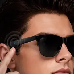 Los lentes puestos, tocando la patilla